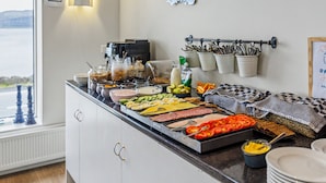 A buffet setup with various food items and utensils.