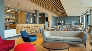 A modern hotel lobby with a bar area, seating arrangements, and a distinctive ceiling design. - Holiday Inn Express Bridgwater M5, Jct. 24 by IHG (Bridgwater)