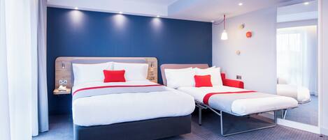 A hotel room with two beds, a large window, and a modern design.