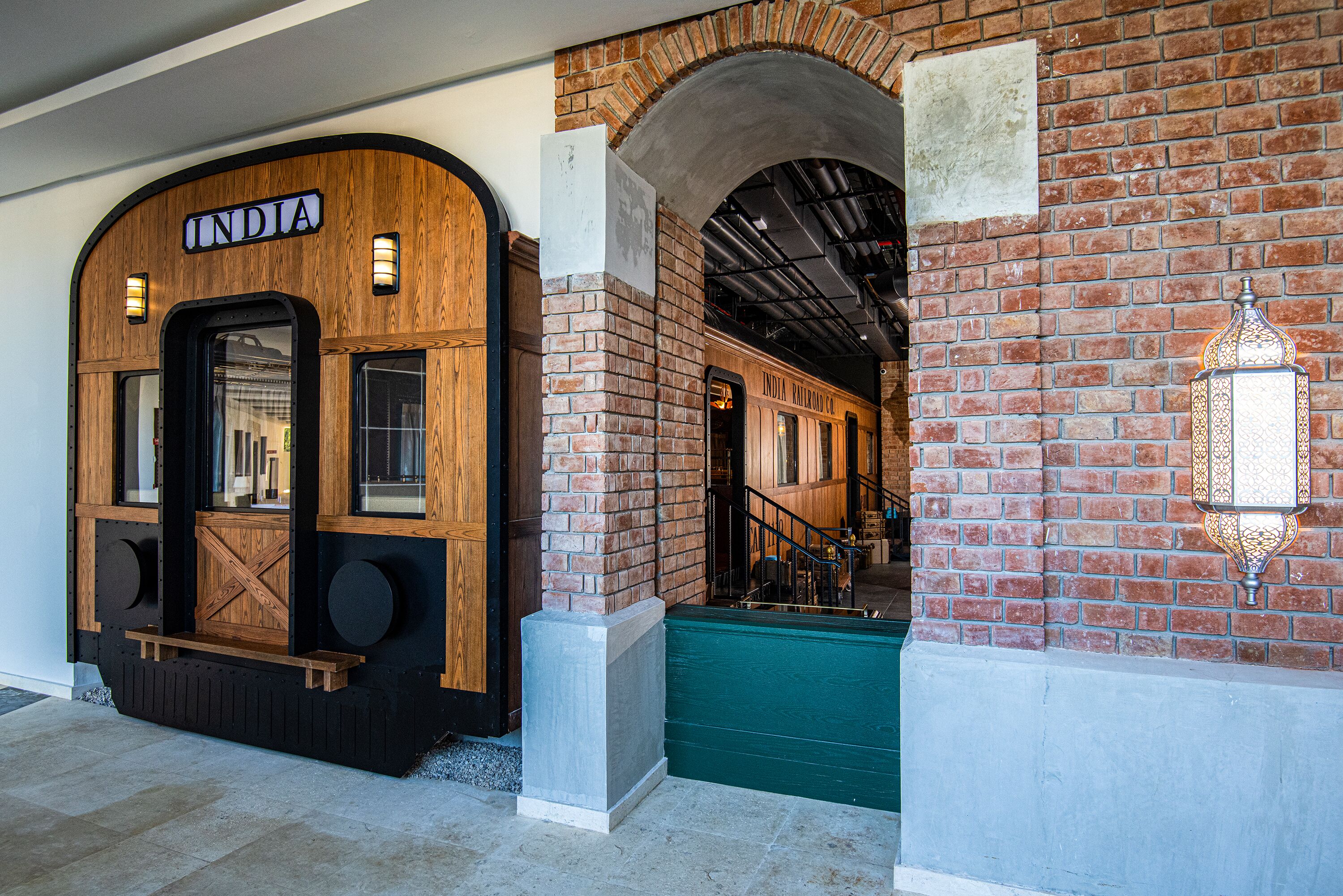 Entrada amb temàtica de tren, façana de fusta i la paraula 'INDIA' a la porta.