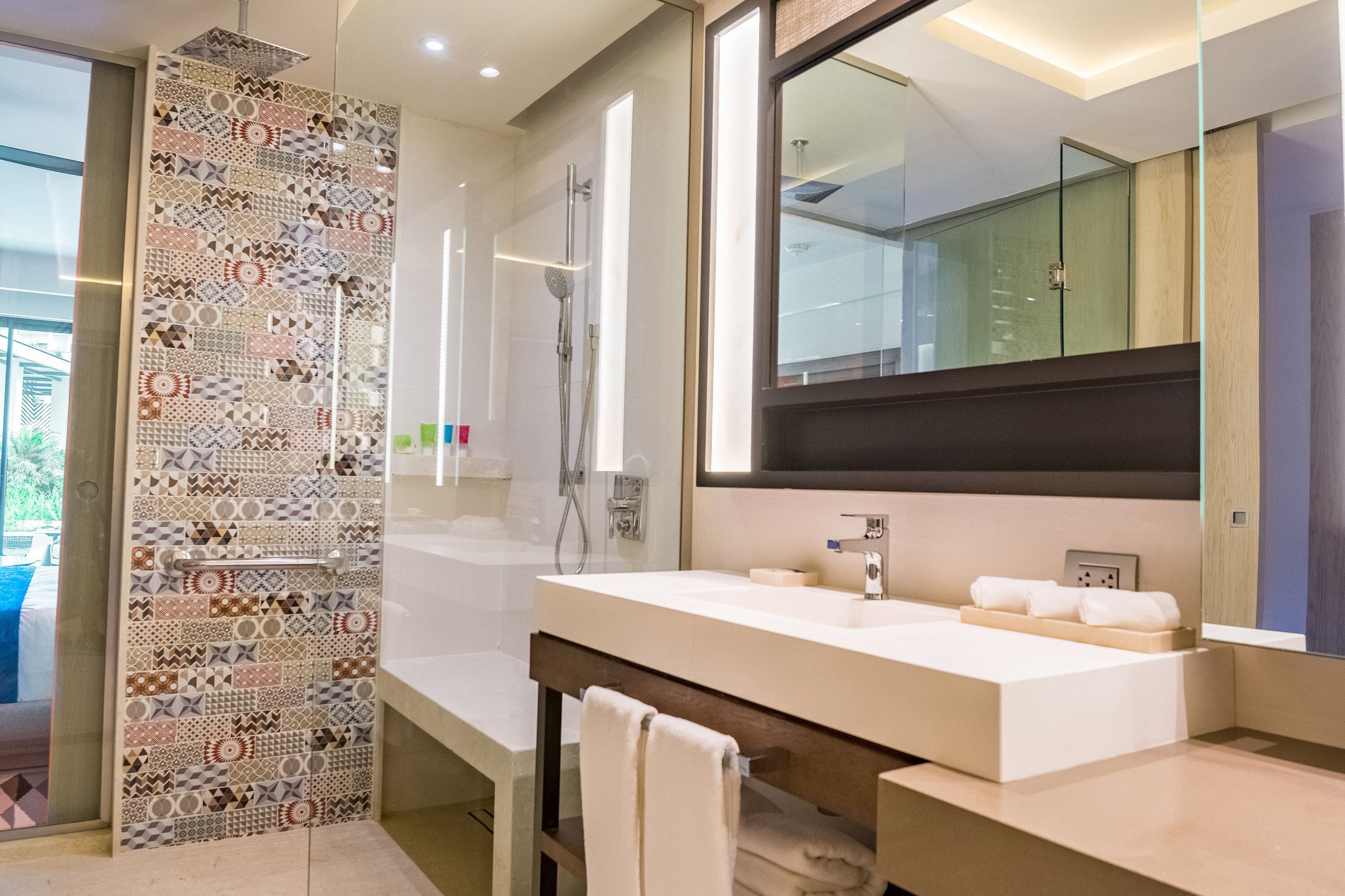Une salle de bain moderne avec un grand miroir, une baignoire et une douche.