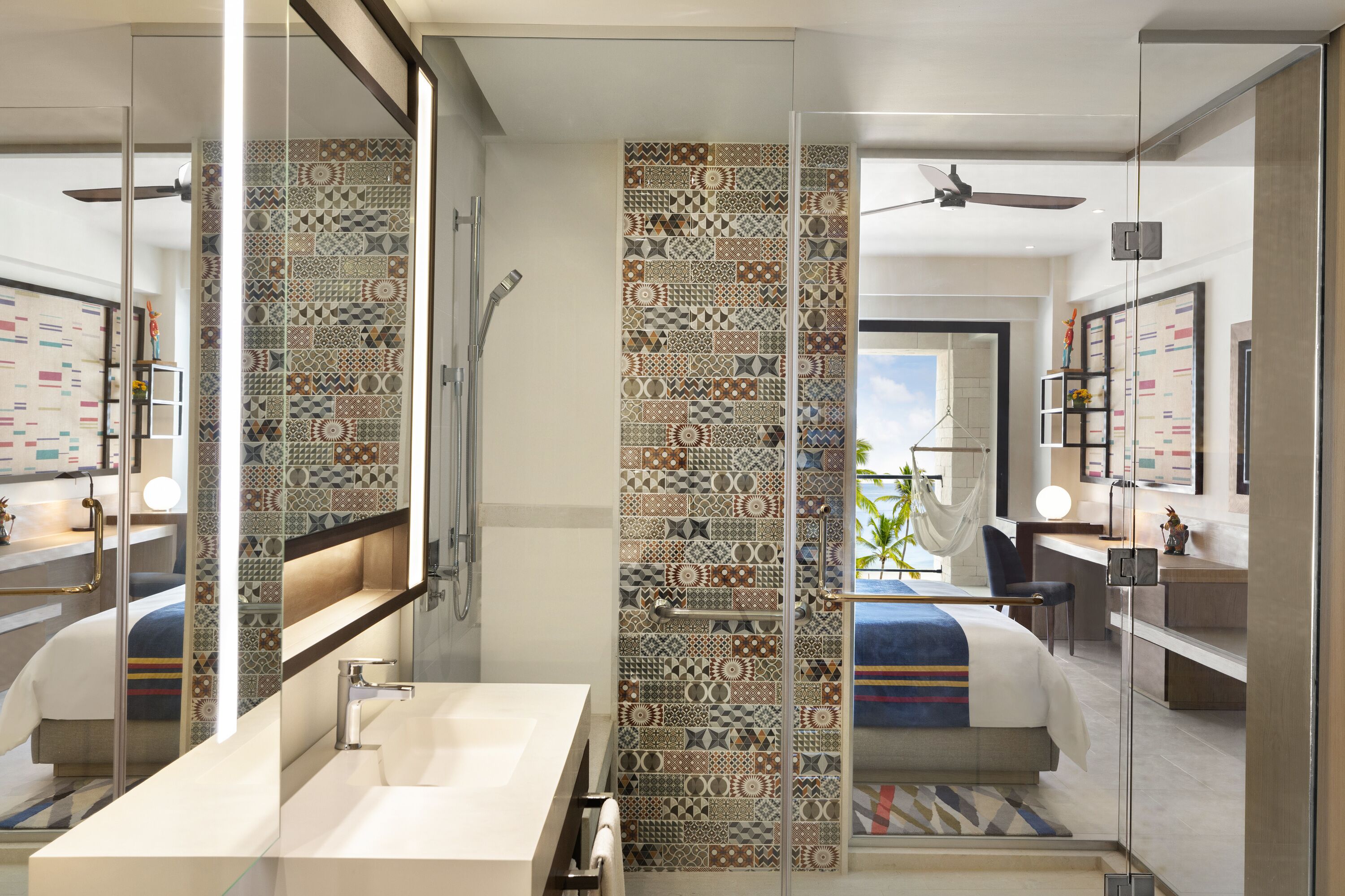 Une salle de bain moderne avec un grand miroir, un lavabo et un espace douche.