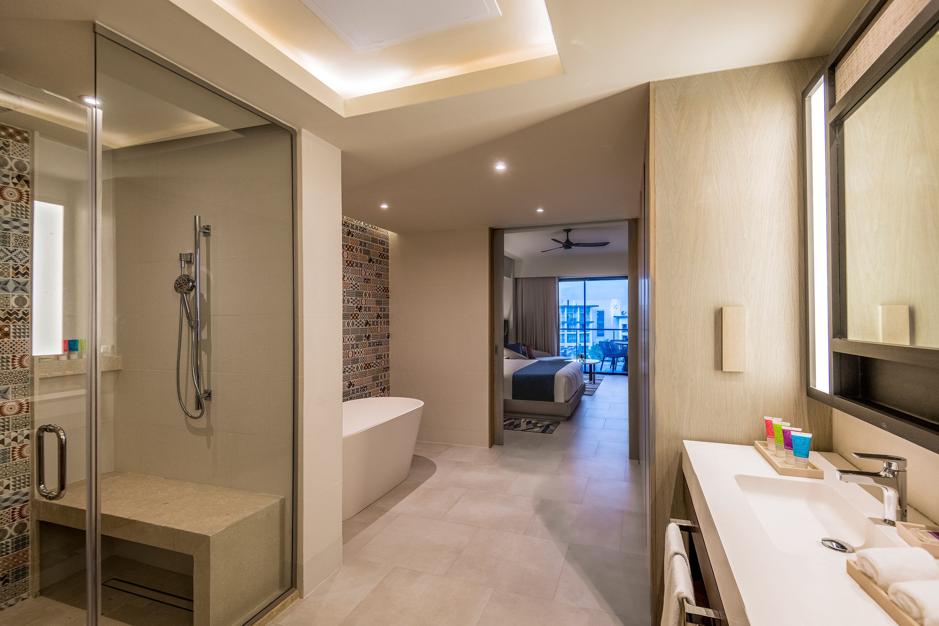 A modern bathroom with a glass-enclosed shower, a freestanding bathtub, and a large mirror.