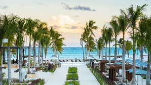 A beachfront resort with a pathway lined with palm trees and beach umbrellas, leading to the ocean. - Hyatt Zilara Cap Cana ‐ Adults Only ‐ All Inclusive (Punta Cana)