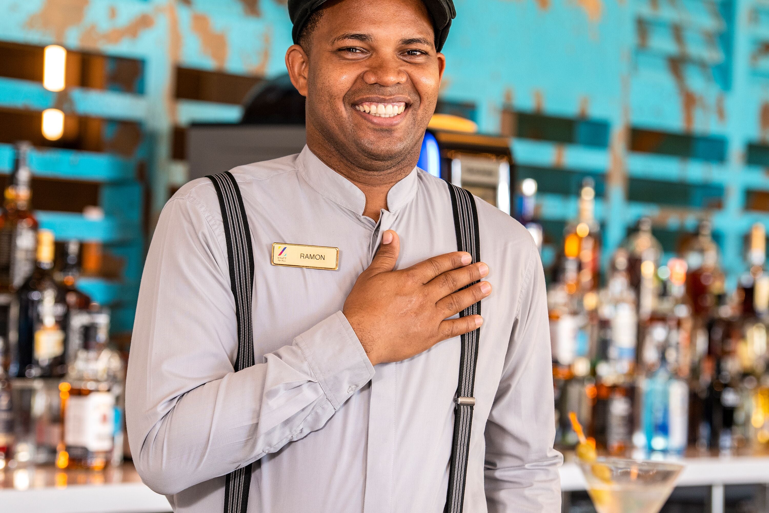 A person in a bar setting with a name tag, a striped tie, and a name tag reading "RAMON".
