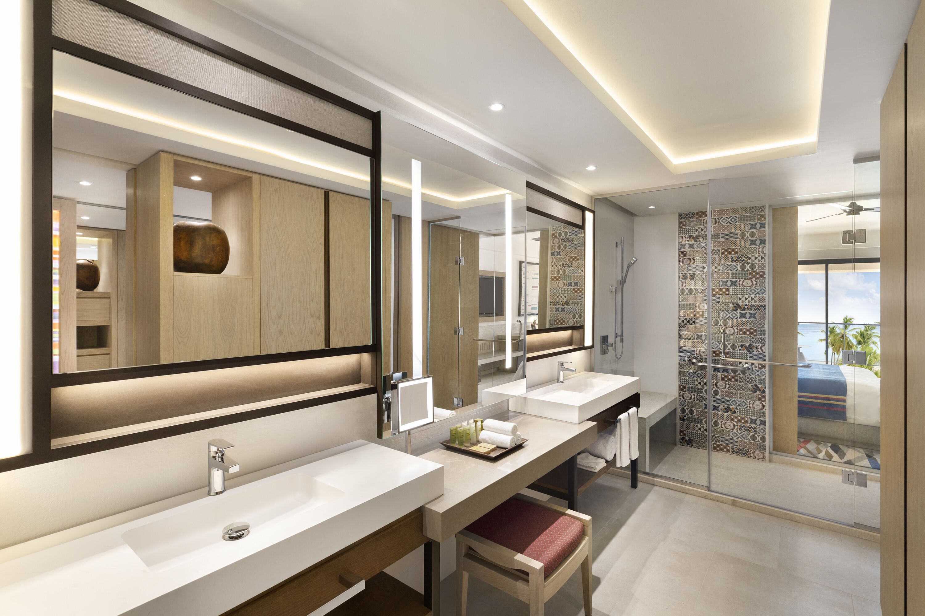 A modern bathroom with two sinks, a large mirror, and a shower area.