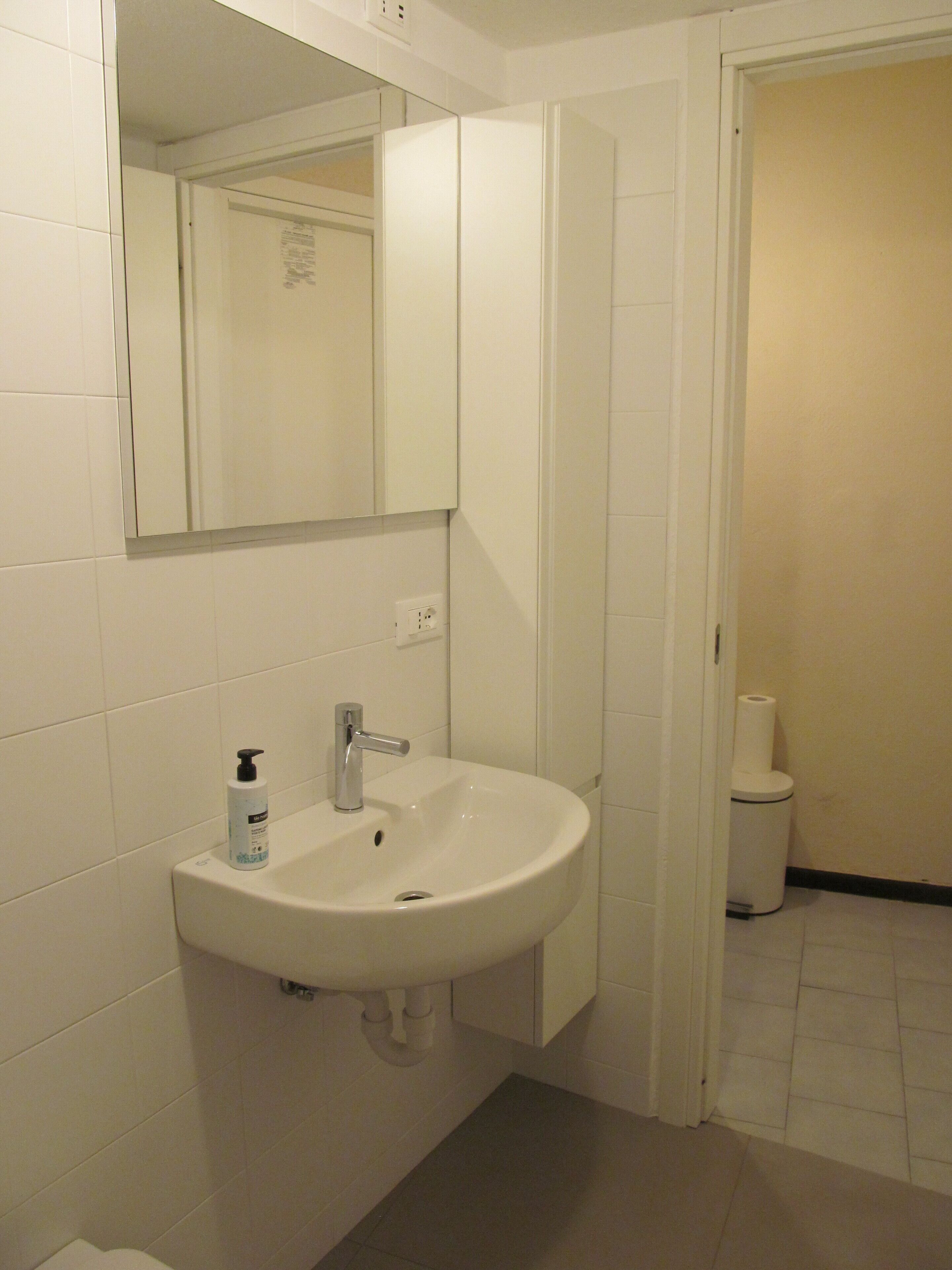 Een badkamer met een wit wastafelmeubel, spiegel en toilet.