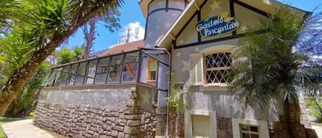 A building with a stone facade and a sign that reads "Castelo Encantado".