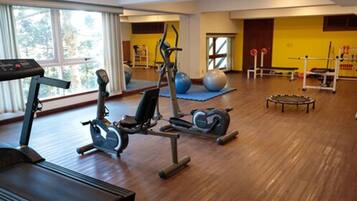 Ein Fitnessraum mit Laufband, Crosstrainer, Heimtrainer und Übungsbällen.