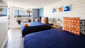 A hotel room with two beds, a desk, and a view of the beach. - Breakwater Hotel (Provincetown)
