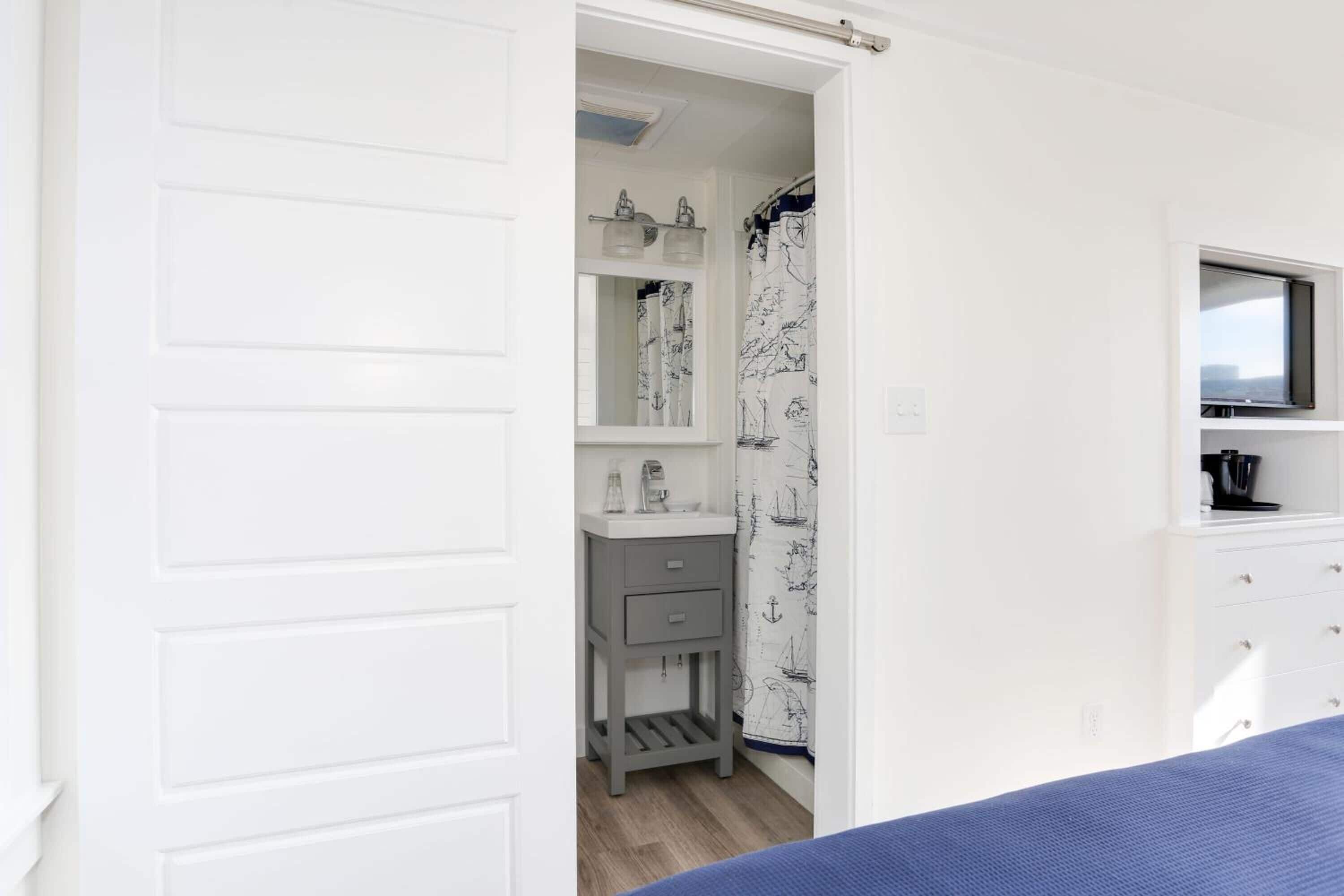 Un dormitorio con cama, televisor, mesita de noche y armario.