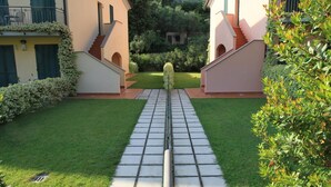 A pathway leading to a building with a garden in the center. - Baia Blu Rta (Lerici)
