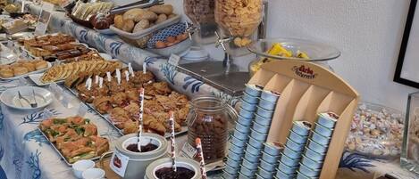 A buffet with various food items, including jars of jam and a meat station.