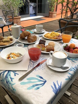 A table set with breakfast items including croissants, fruit, and coffee.