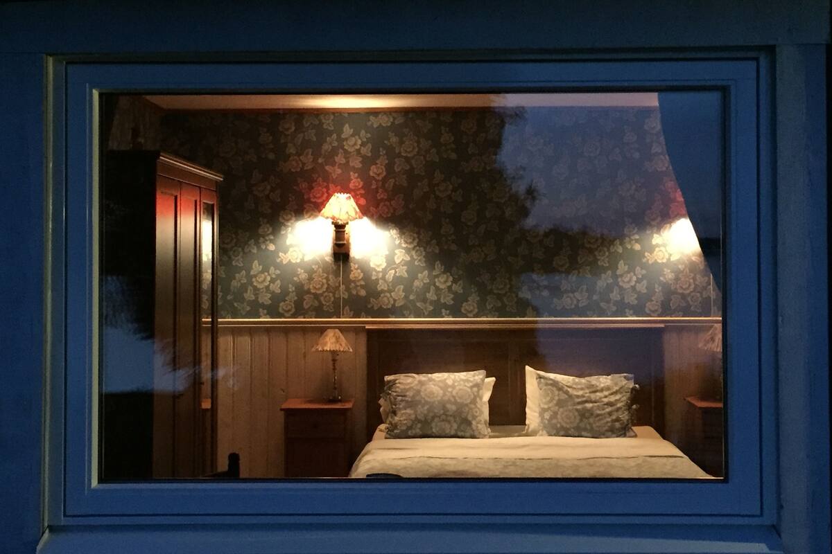 Une chambre à coucher avec un lit, deux tables de chevet et une commode.