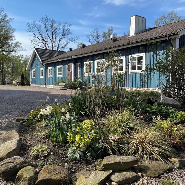 A traditional blue house with a tiled roof, a chimney, and a gravel driveway. - Hägern Bed & Nature (Bolmsö)