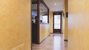 A hallway with wooden flooring and a reception desk. - La Tintoreria (Villablino)