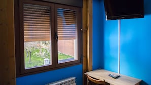 A room with a window, a radiator, a desk, and a television. - La Tintoreria (Villablino)