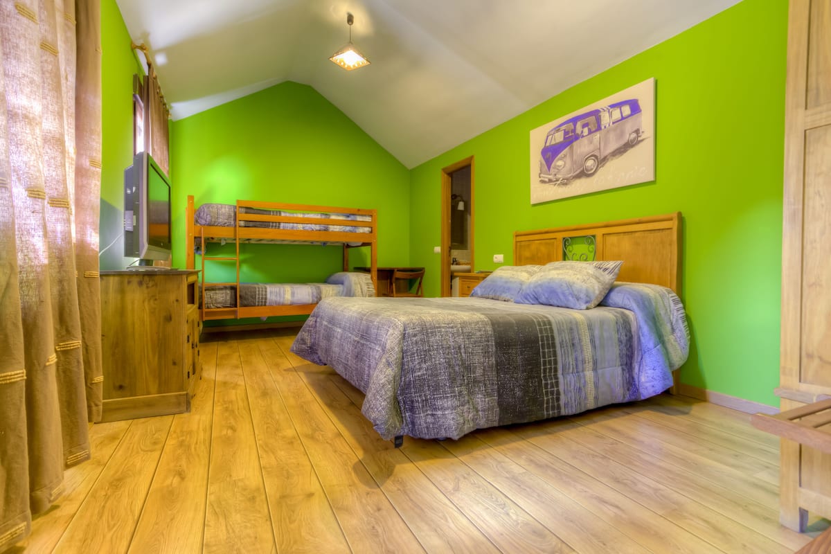 A room with bunk beds, a wooden wardrobe, and a painting on the wall.