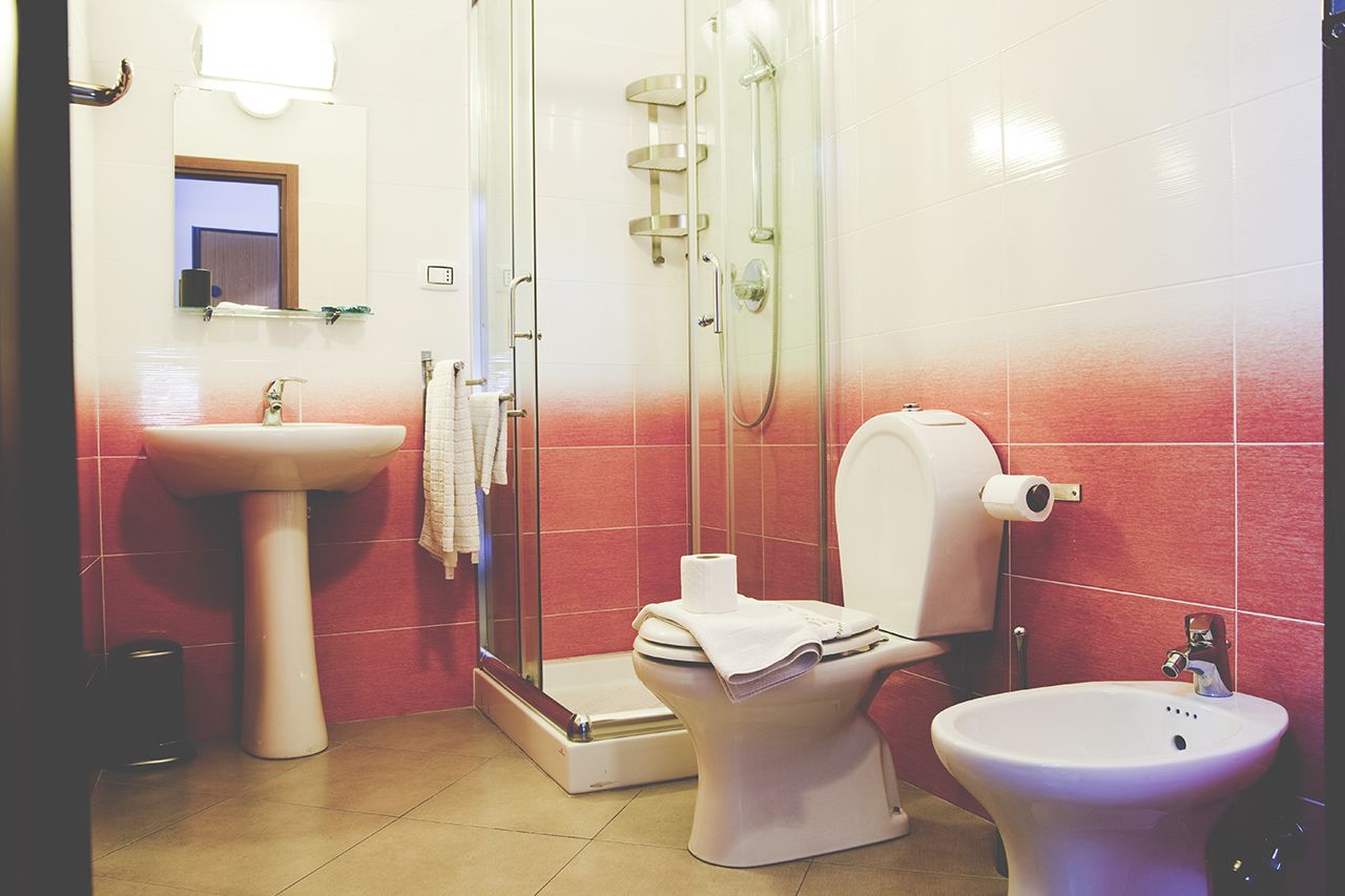 A bathroom with a toilet, bidet, and sink.