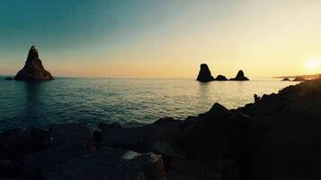 A coastal landscape with rocky formations and calm waters.