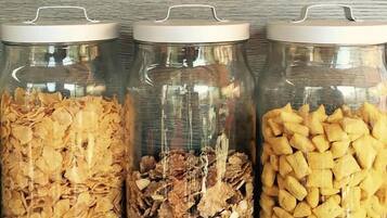 Tres frascos de vidrio con tapas metálicas que contienen diferentes tipos de alimentos secos.