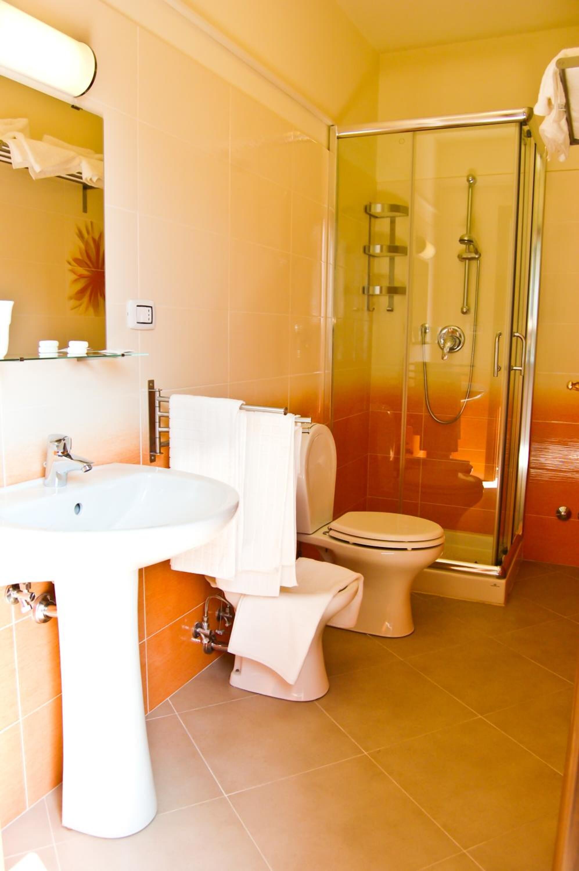 A bathroom with a sink, toilet, and glass-enclosed shower.
