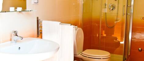 A bathroom with a sink, toilet, and glass-enclosed shower.