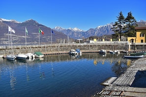 Un port de plaisance avec des bateaux amarrés, un quai et des montagnes en arrière-plan.
