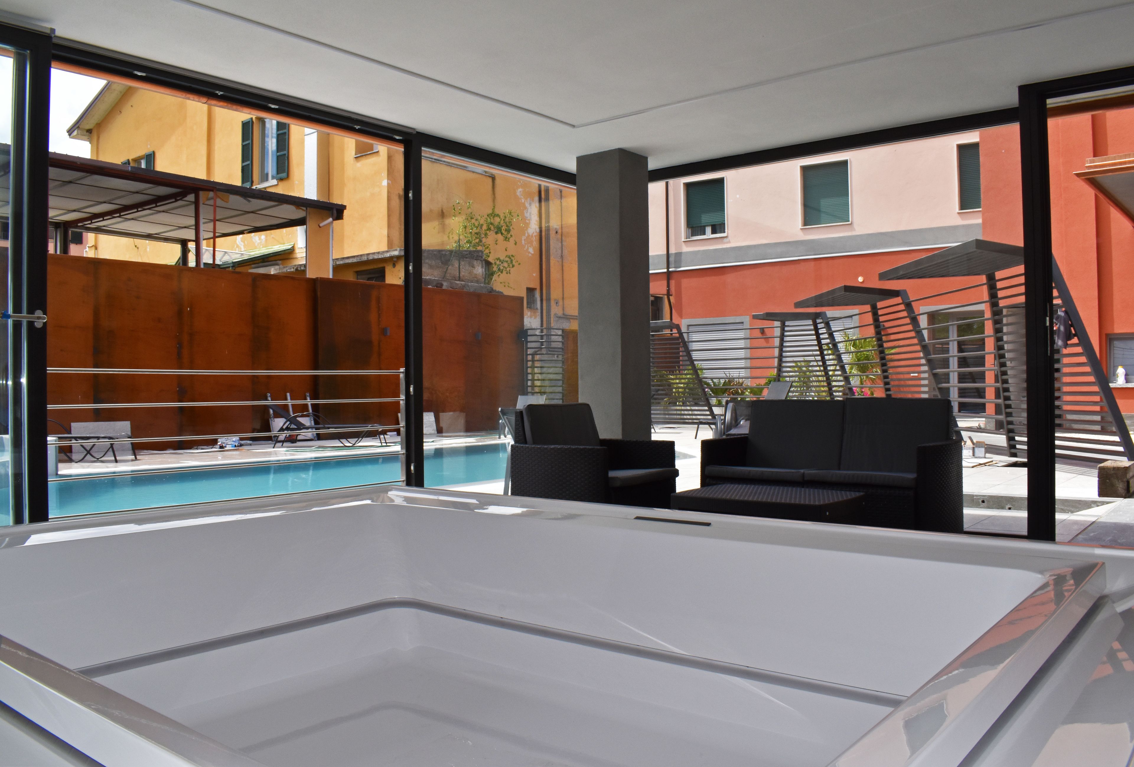 Un espace piscine intérieur moderne offrant une vue dégagée sur les bâtiments environnants.