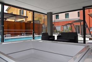 Un área de piscina interior moderna con vista despejada a los edificios exteriores.