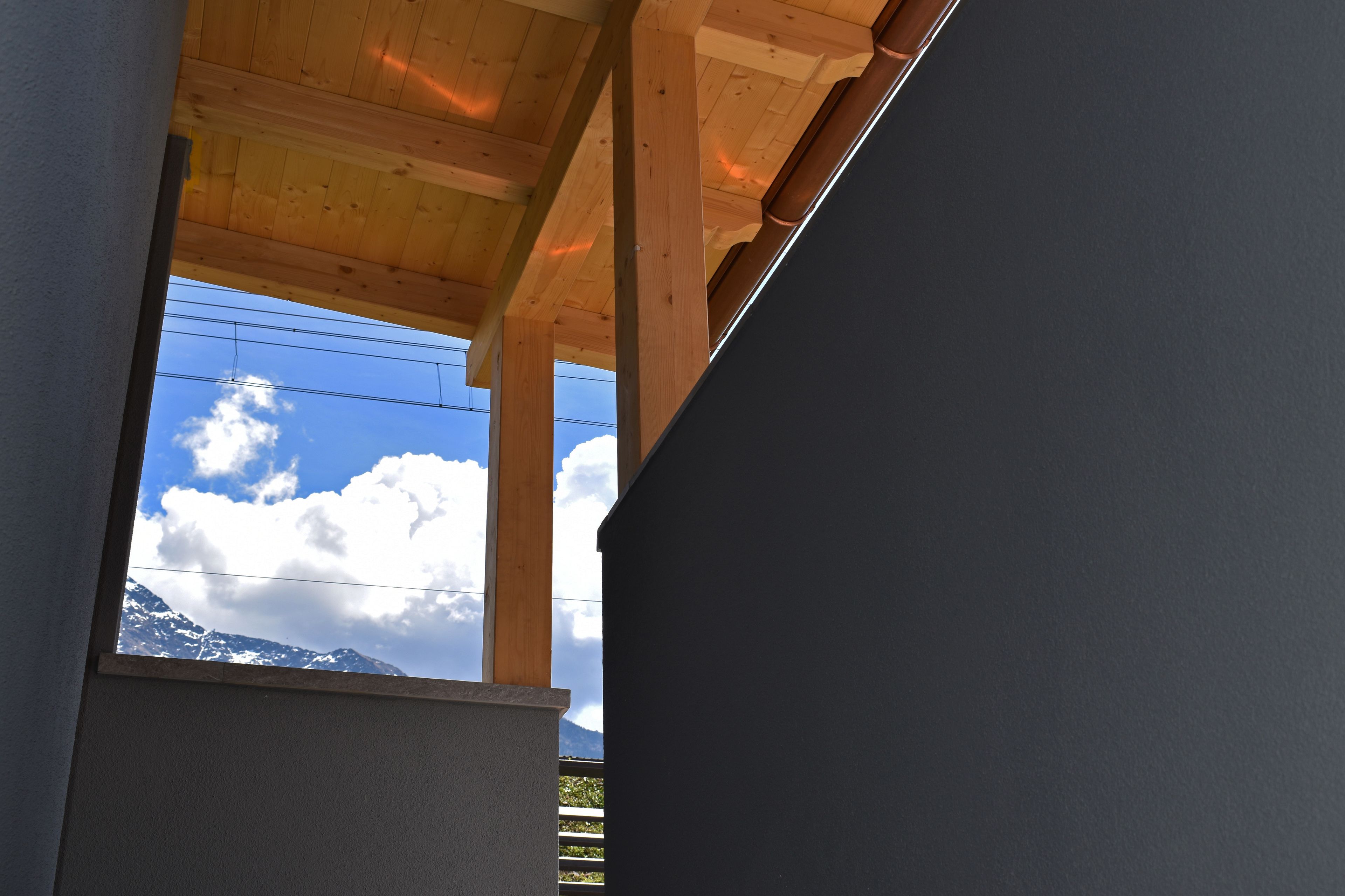 Blick durch ein Fenster mit Holzbalken und einem Berg im Hintergrund.