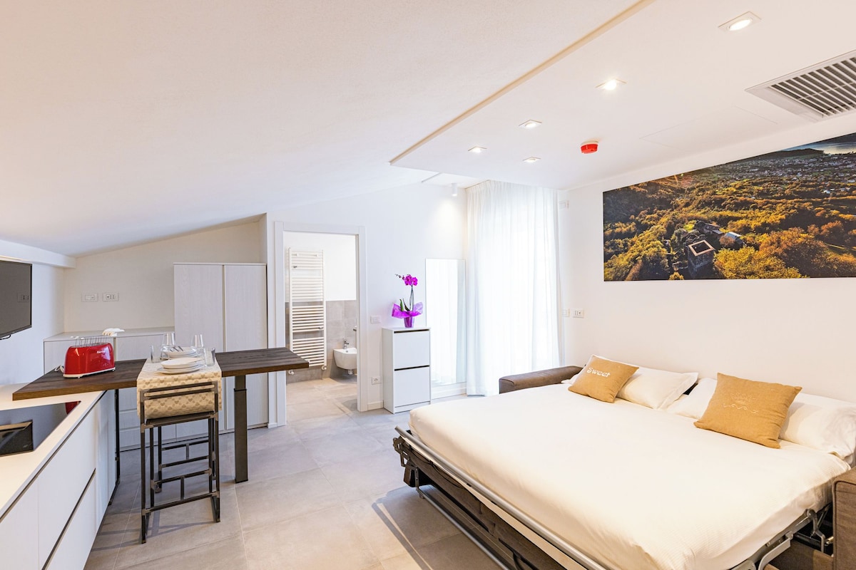 Une chambre d’hôtel moderne équipée d’un lit, d’un bureau et d’une salle de bain.