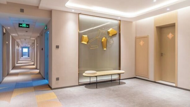 A modern hotel corridor with a bench, a glass wall with geometric decorations, and a door on the right. - Jinjiang Inn (Tianshui)