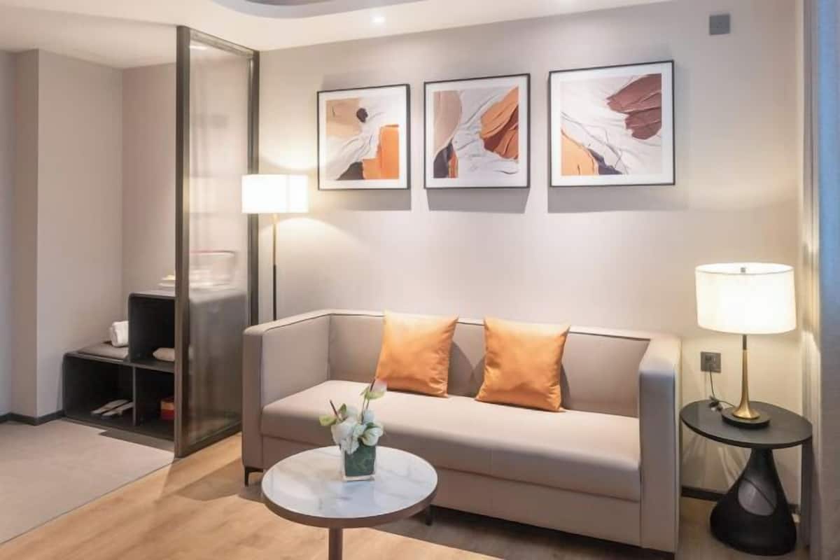 Una sala de estar moderna con un sofá, una mesa de centro y decoración en la pared.