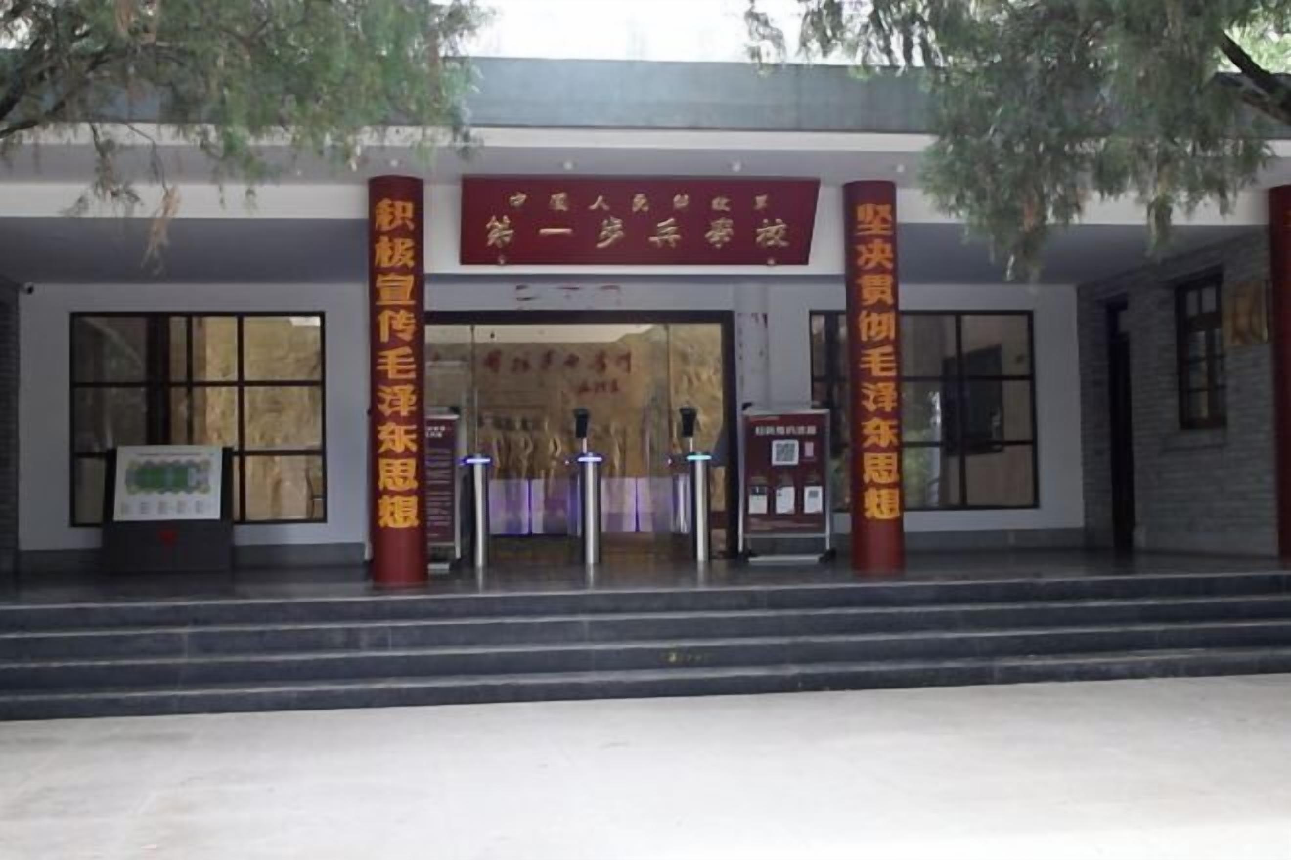 A building entrance with a red banner and two red pillars with gold text.