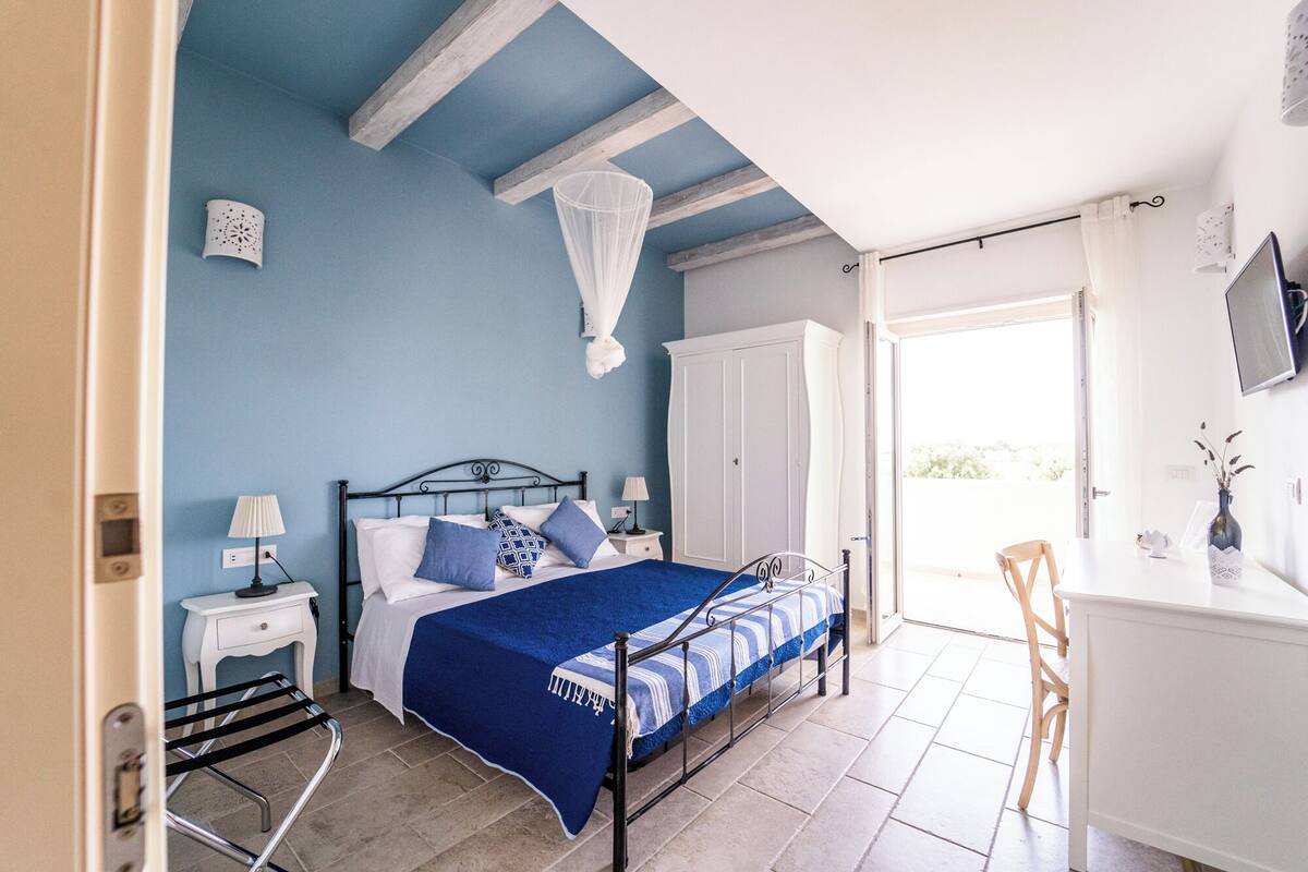 A bedroom with a bed, bedside tables, a wardrobe, and a chair.