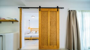 Habitació moderna amb una porta corredissa, un llit, una tauleta de nit i una estant amb pots.
