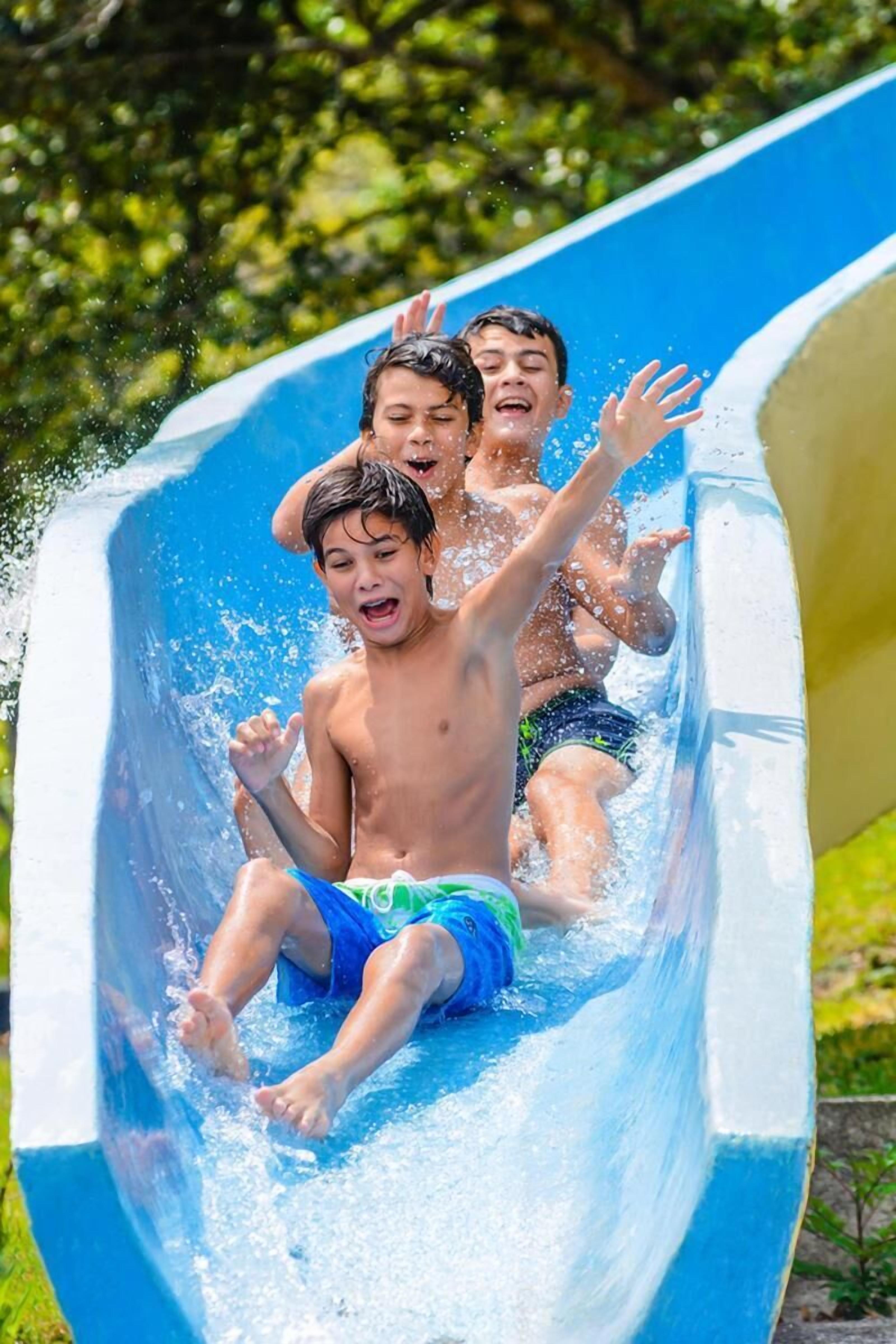 Niños resbalando por un tobogán acuático.