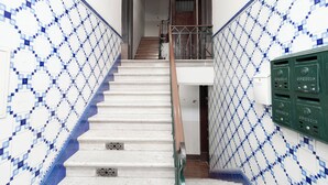 Una escalera con peldaños blancos y azulejos decorados con motivos azules en las paredes.