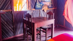 Ein Holzes Esstisch mit Stühlen, ein dekorativer Fächer und eine Wand mit geometrischem Muster.