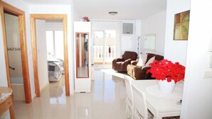 A spacious living area with a sofa, a coffee table, and a potted plant.