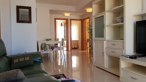 Relax in this inviting living room with a sofa, dining area, and convenient cabinet storage.