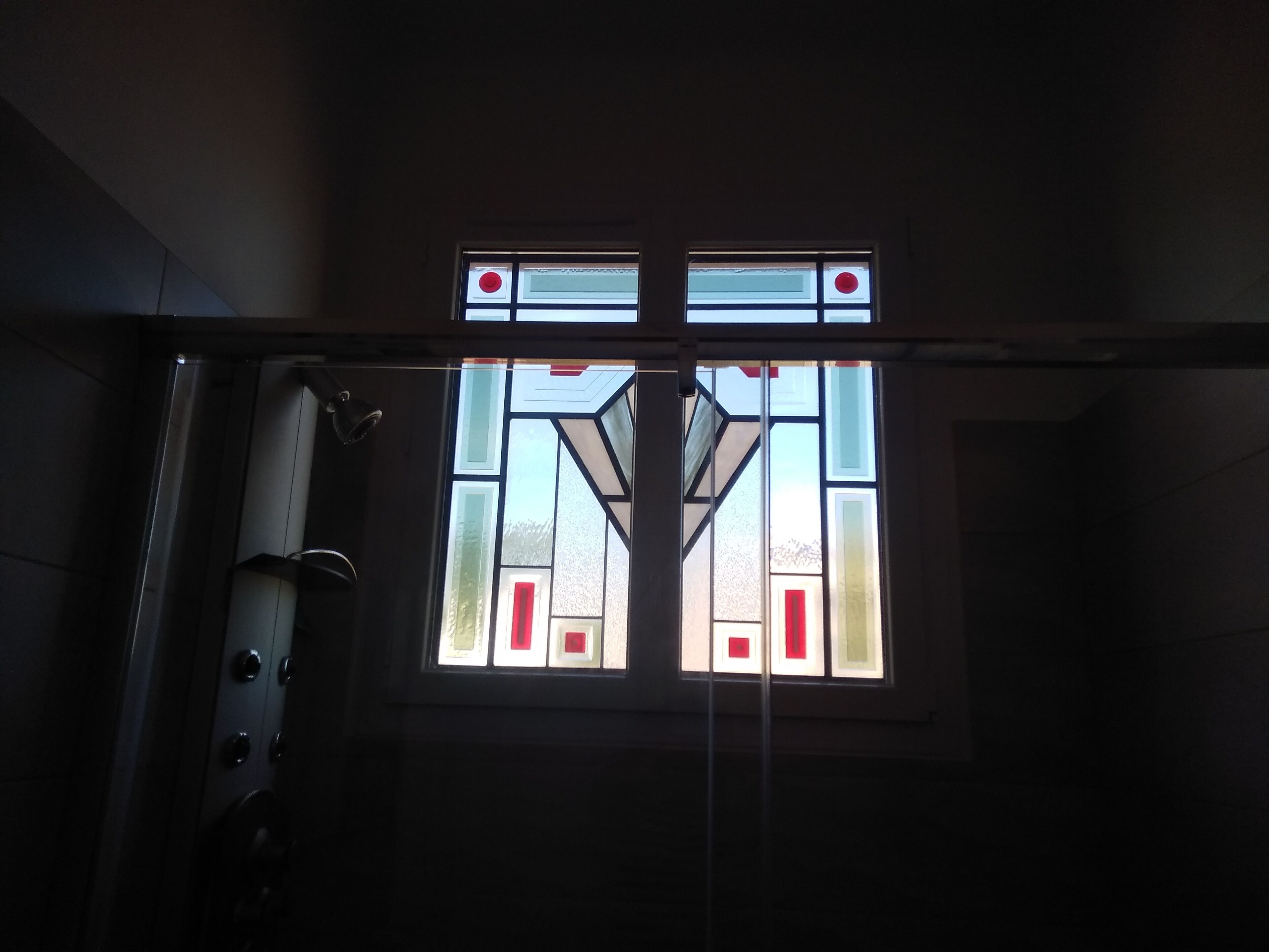 Una ventana con diseños geométricos y un círculo rojo.