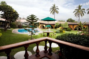 Una piscina al aire libre, sombrillas, sillones reclinables de piscina