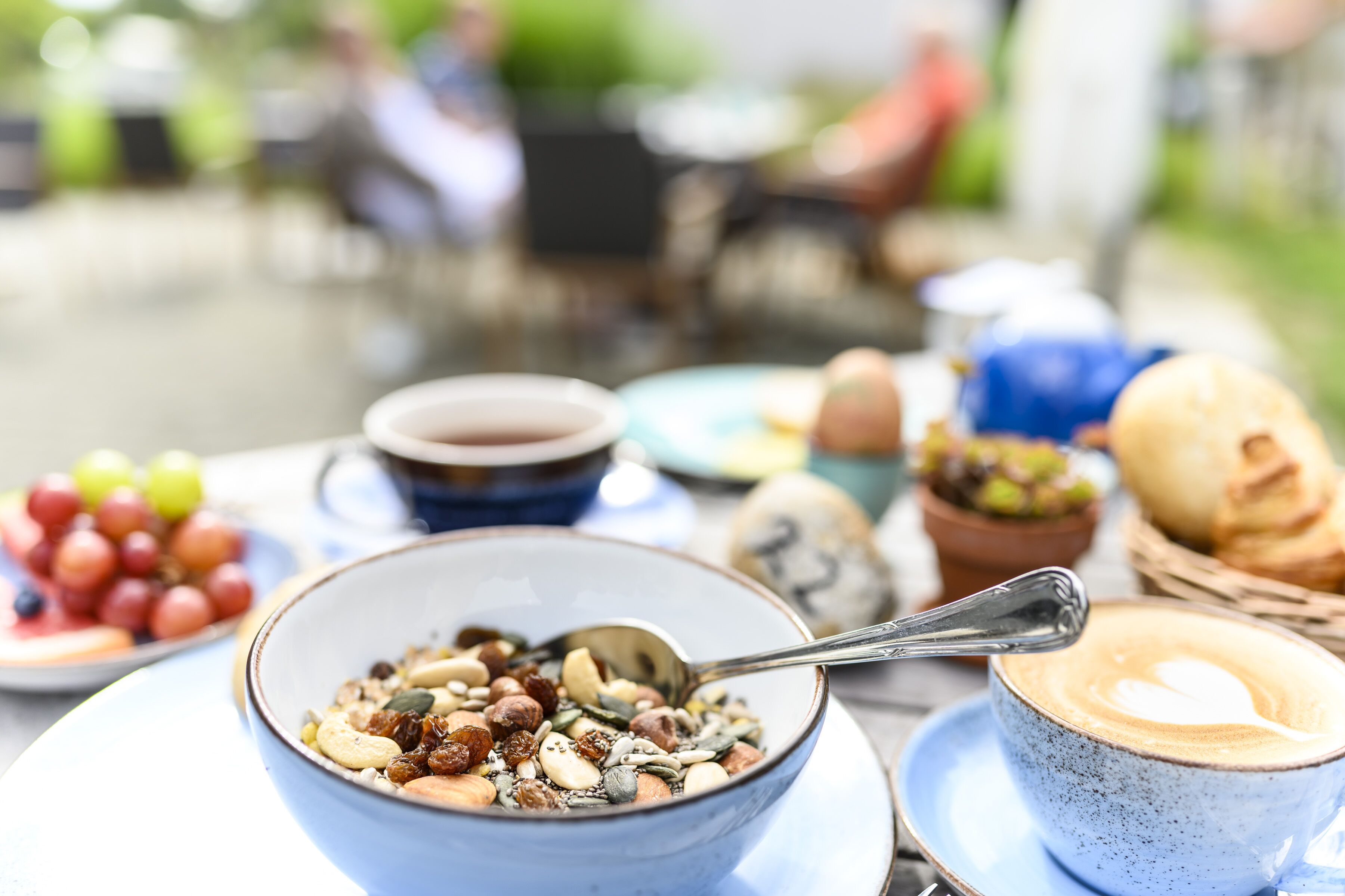 En morgenmadsopstilling med skålsat cornflakes, en kop kaffe og et fad med druer.