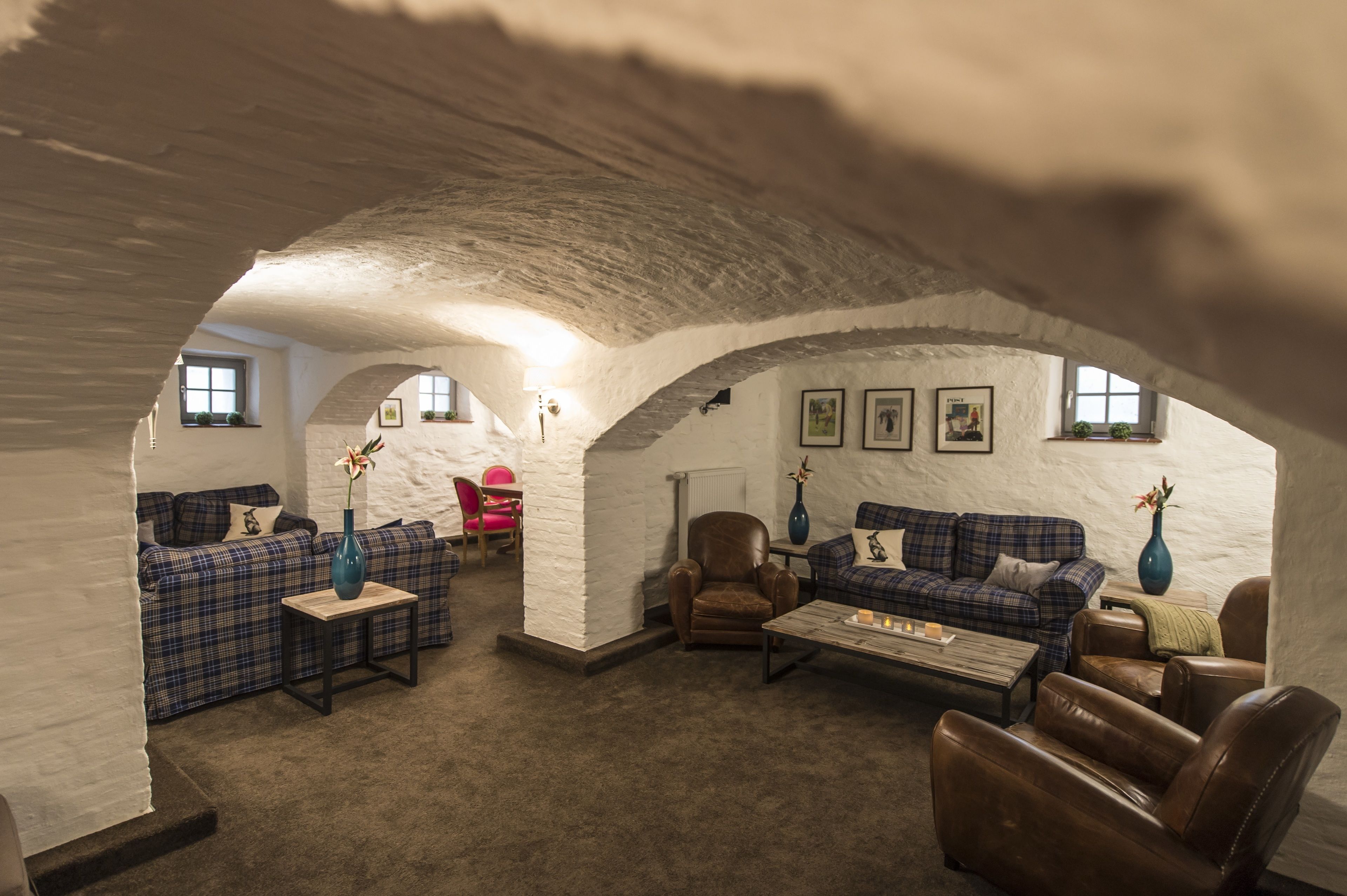 Una sala de estar acogedora, con techos abovedados, chimenea, asientos mullidos y vistas al exterior.