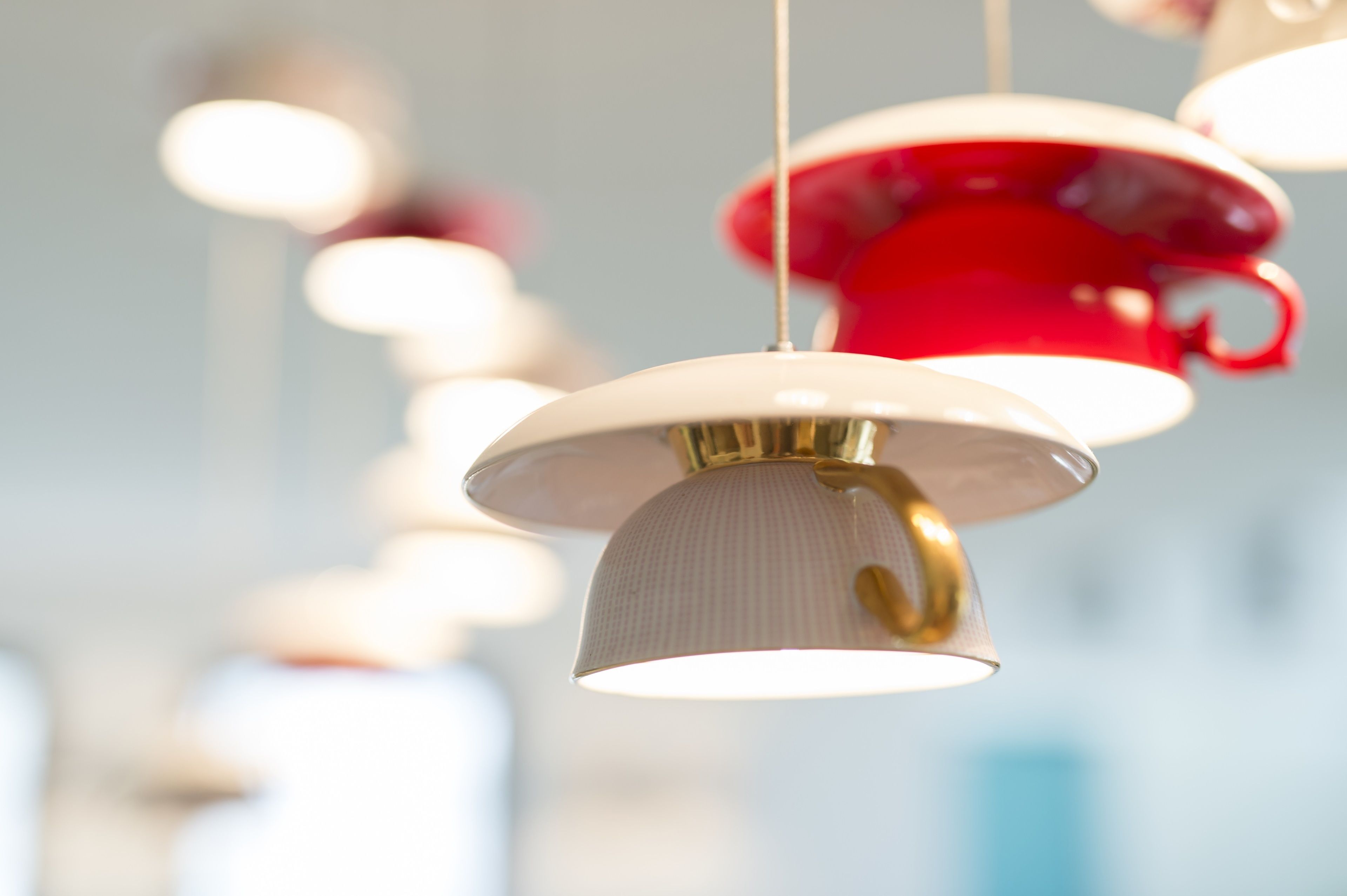 A series of hanging pendant lights with a white and red color scheme.