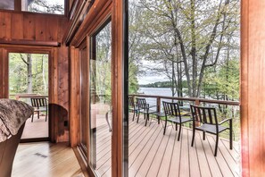 Une terrasse en bois avec des sièges extérieurs donnant sur un lac.