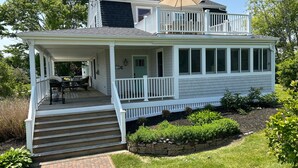 A two-story house with a covered porch, a stone retaining wall, and a brick pathway leading to the front door. - Open Floor Plan, Family Friendly, Waterview Home  (Narragansett)